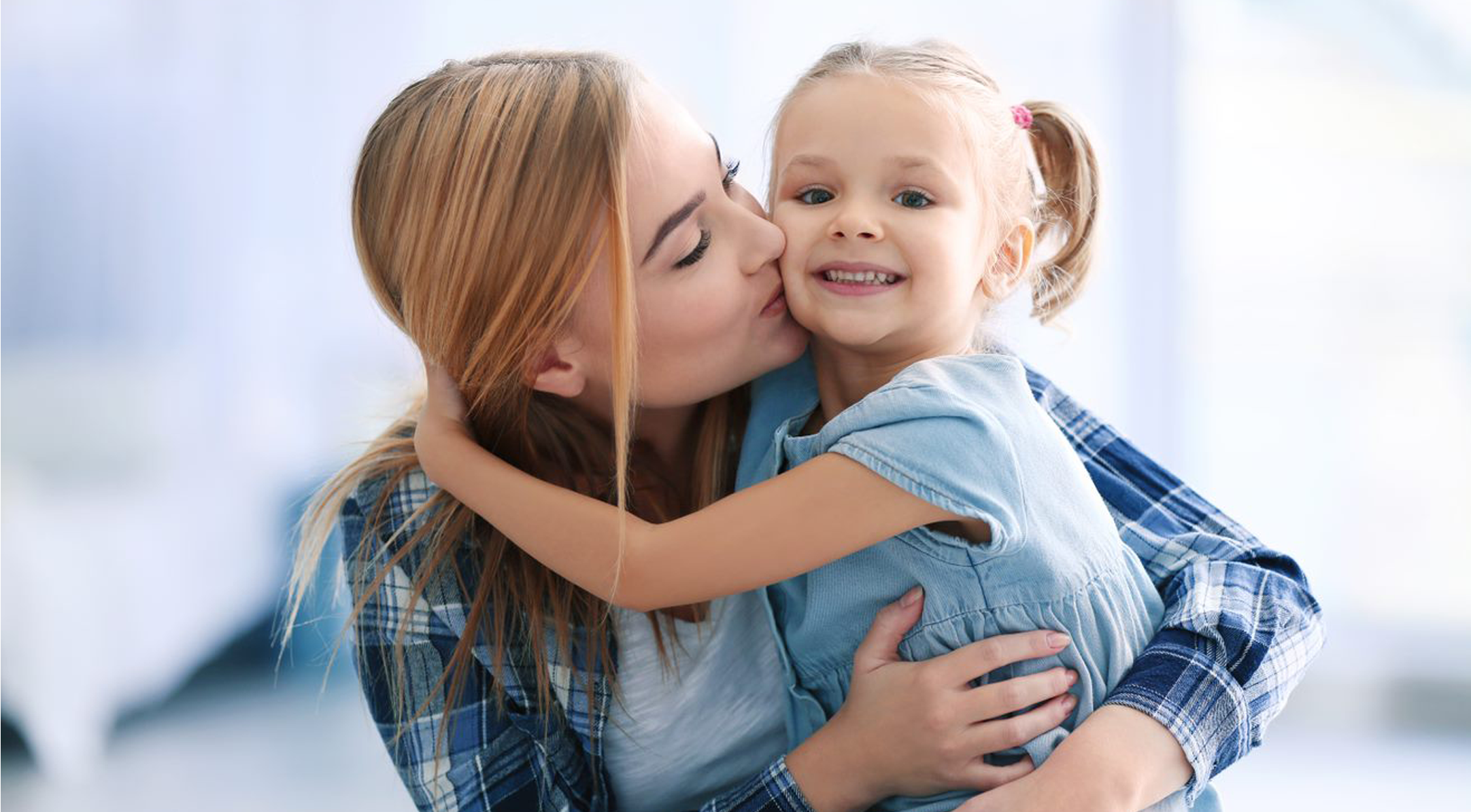Mom kissing her child on the cheek