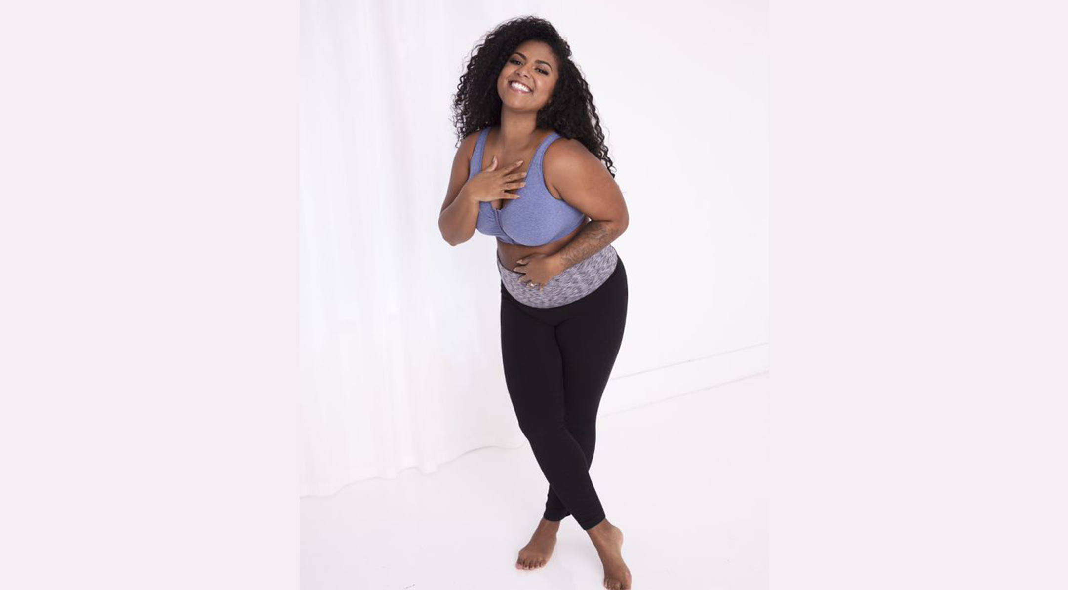 Woman standing wearing a front closure bra and leggings