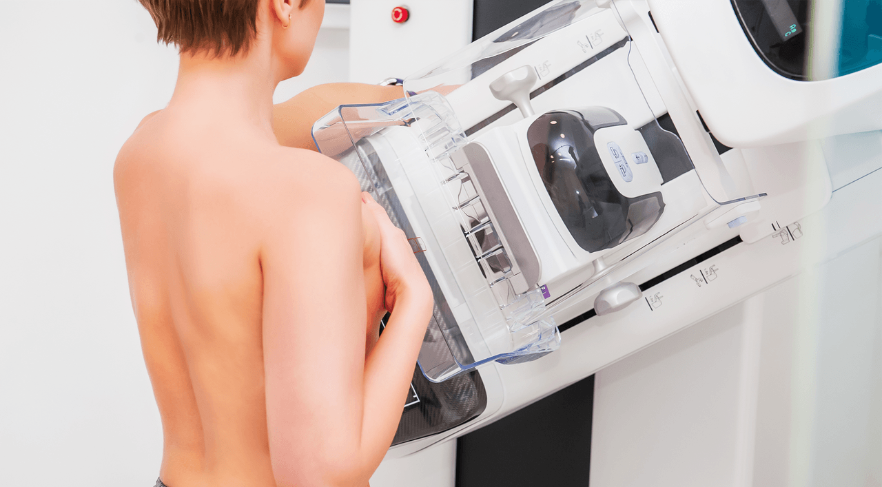 Woman getting a mammogram with back facing viewer