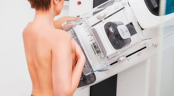 Woman getting a mammogram with back facing viewer