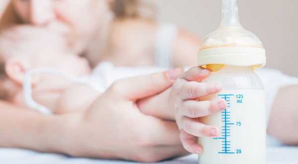 Close-up baby holding bottle