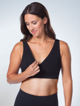 Front view with cup pulled aside of cross over sleep and comfort bra in jet black
